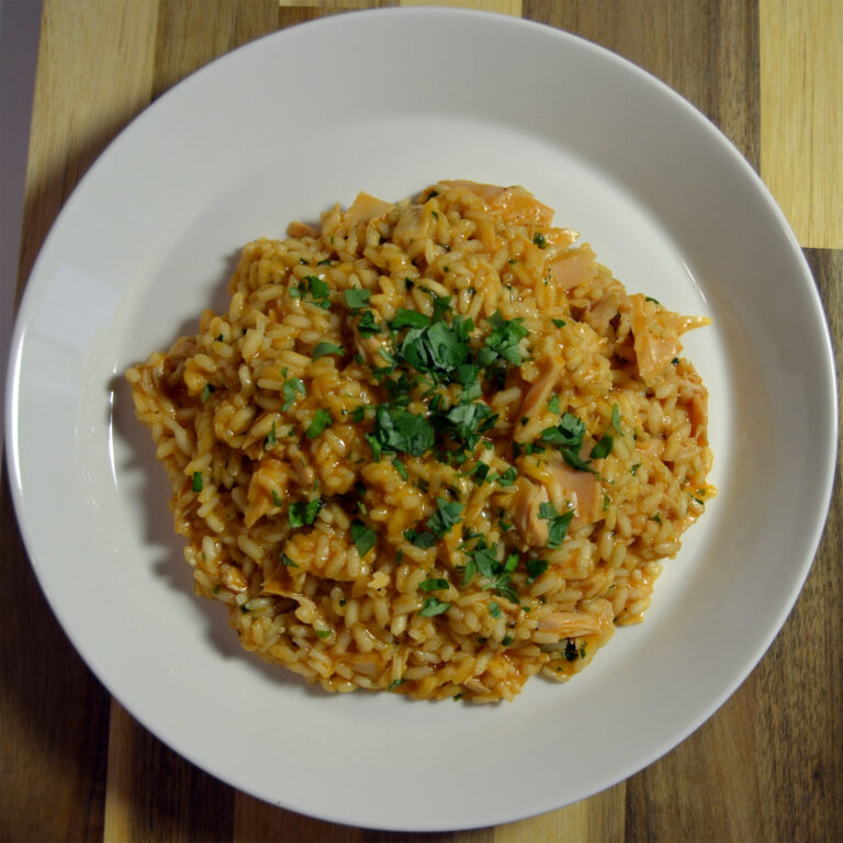Tuna risotto served on a white plate, topped with parsley.