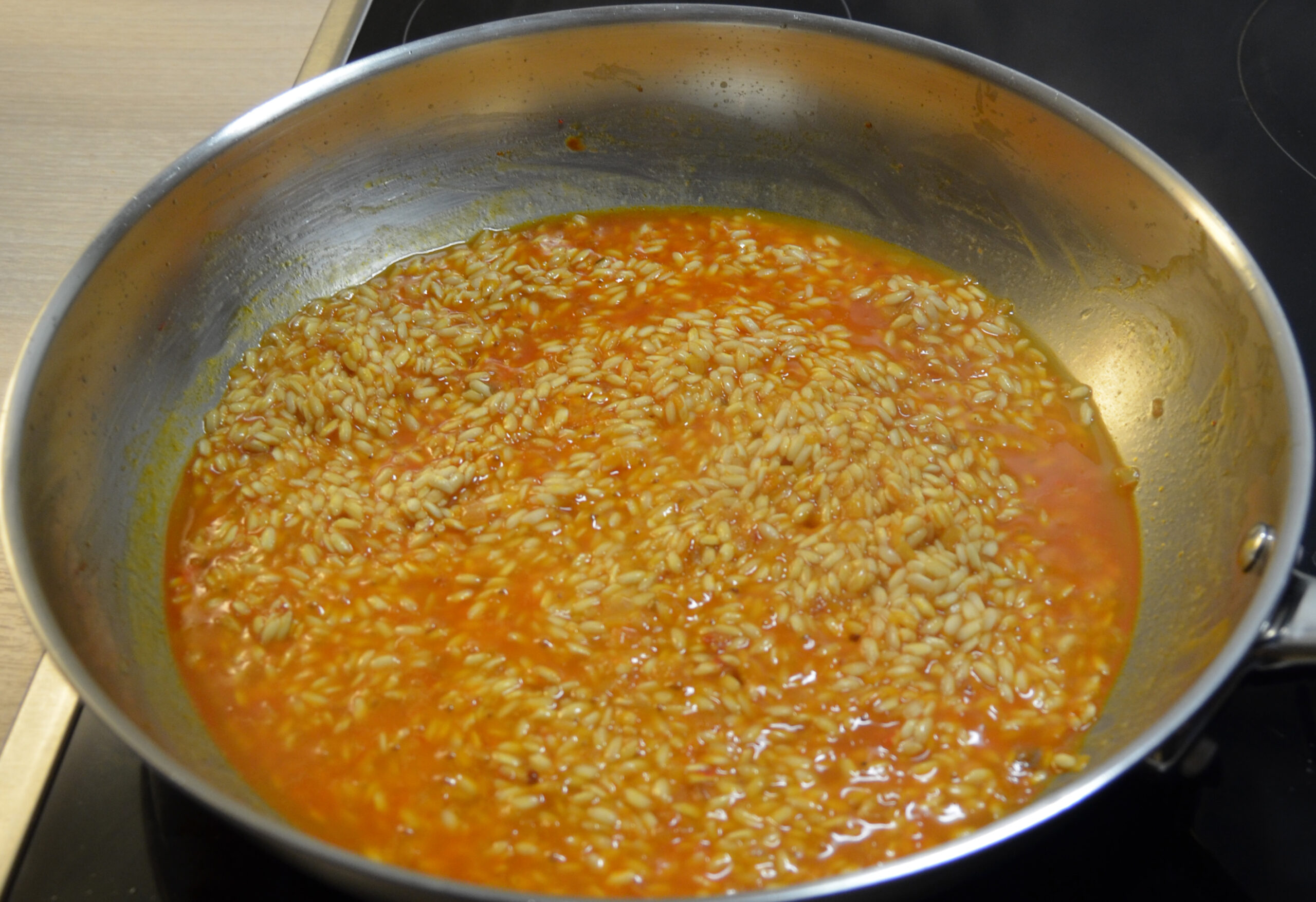 Risotto simmering in a skillet.