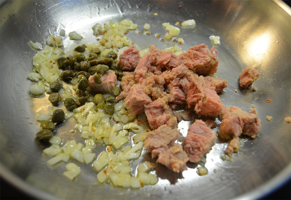 Tuna, onion, garlic and capers on pan.